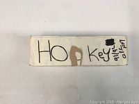 White labeled box with handwritten 'Hockey' text on the side, showing age and usage wear.