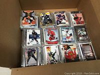 Box filled with multiple stacks of NHL hockey trading cards, visible front cards displaying various players.