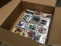 View of multiple sealed packs of NHL hockey cards in clear sleeves, showing players in various poses and team uniforms.