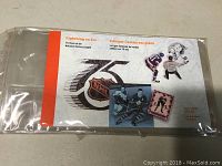 Front of the collector stamp booklet showing the title 'Lightning on Ice', NHL logo, with hockey player and referee images, encased in clear plastic sleeve.