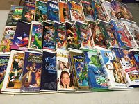 VHS movie tapes arranged in rows showing various titles including Disney films and other family movies.
