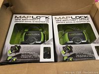 Six Maplock GPS anti-theft devices visible inside open box, showing front of packaging with device inside.