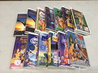Multiple new sealed Disney VHS movies arranged standing, showing spine labels including Dragonheart, Snow White, Lady and the Tramp, Bambi, Beauty and the Beast, Cinderella, The Lion King, Pocahontas, The Aristocats, and The Wizard of Oz.