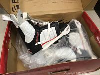 Wakeboard bindings in box showing black, white, and red colors, and laces