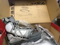 Photo of Liquid Force Alpha wakeboard binding inside original box showing the white and gray boot and F.A.S.T. fine adjustable stance system print on the box lid.