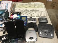Overview of lot showing keyboards, phones, controllers, and audio devices on table.