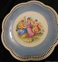 Front view showing reticulated rim, blue lustre border and Three Graces scene