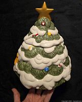 Front view of ceramic Christmas tree cookie jar with gold star lid