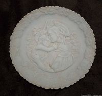 Front view of light blue satin glass plate with bas-relief Madonna and child scene