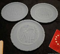 Three blue satin glass plates laid out