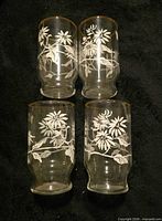 Front view of all four glasses showing floral and butterfly motif and gold rims