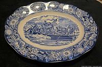 Full view of blue and white oval platter with floral border and Washington Crossing scene
