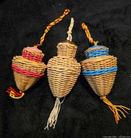 Front view of three wicker ornaments showing sizes and colored accents