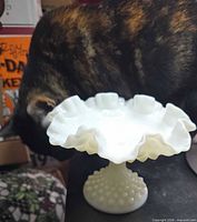 Side view of compote showing hobnail pattern, pedestal base, and ruffled rim