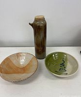 Group shot of brown glazed vessel and two decorative bowls