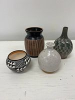 All four pottery pieces grouped on table