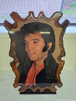 Front view of wood-backed portrait showing Elvis Presley image and carved wood frame