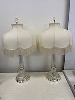 Front view of both crystal lamps showing bases, shades, mismatched finials