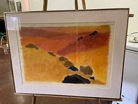 Full view of framed pastel artwork on easel