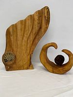 Front view of both sculptures showing fossil inset and curled form with sphere