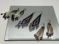 All three pairs of seed bead fringe earrings on mirror