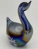 Front angled view of iridescent cobalt glass swan with white mottled base