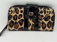 Front view of wallet showing leopard Hello Kitty pattern, black patent trim, wristlet strap