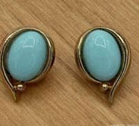 Front view of both Trifari gold-tone clip-on earrings with turquoise cabochons