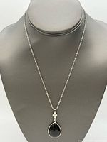 Full view of necklace on display bust showing chain and pendant