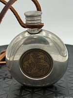 front view of flask showing Celtic horse medallion and cap