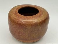 Front view of rounded speckled glaze vase