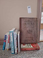 Group of atlas with cookbooks lined against wall