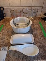 overall lot showing measuring cups, bowls, casserole, butter dish, spoon rest