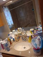 Bathroom counter with assorted toiletries, tissue pack, wipes, dispensers and bottled water