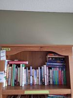 Full view of upper shelf with row of vertically arranged books and shelf structure