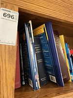 Shelf with multiple reference books including dictionaries and guidebooks