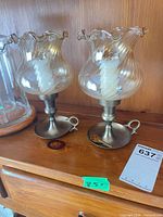 Front view of two hurricane candle holders on metal bases