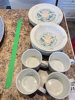 Stack of six plates and four mugs on countertop
