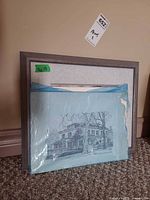 Framed floral print and sealed architectural print leaning together