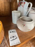 Coffee pot, mugs, glitter pillar candle and floral bowl on shelf