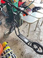 Side view of black Curb Blaster scooter showing frame, deck, both pneumatic tires