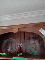 Overview showing two glass plates and red tree ornament on shelf