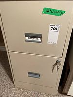 Front view of beige 2-drawer SteelWorks file cabinet with key in lock