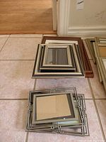 Stacked assorted metal and wood frames on floor