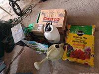 Group shot showing potting mix bag, sprayer, watering can, grass seed bag, paper bags