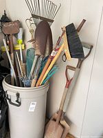 Bin of assorted garden tools; shows variety and condition