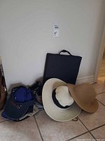 Lot overview showing boots, hats, ball caps, cushion, pouch