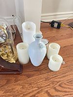 Group showing both clocks, candles, blue vase, jar candle