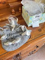 Group of Hoselton polished aluminum figurines on felt pad with crystal piece and box visible