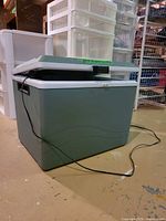 Cooler front/side view with lid ajar and power cord visible